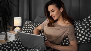 Frau mit Laptop im Bett